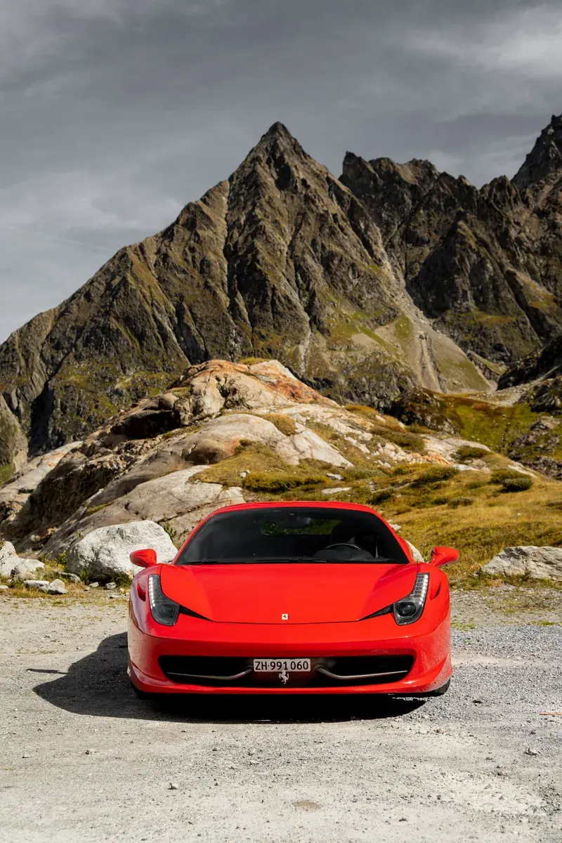 Ferrari 458 Italia in Rosso Corsa von vorne vor einer alpinen Bergkulisse