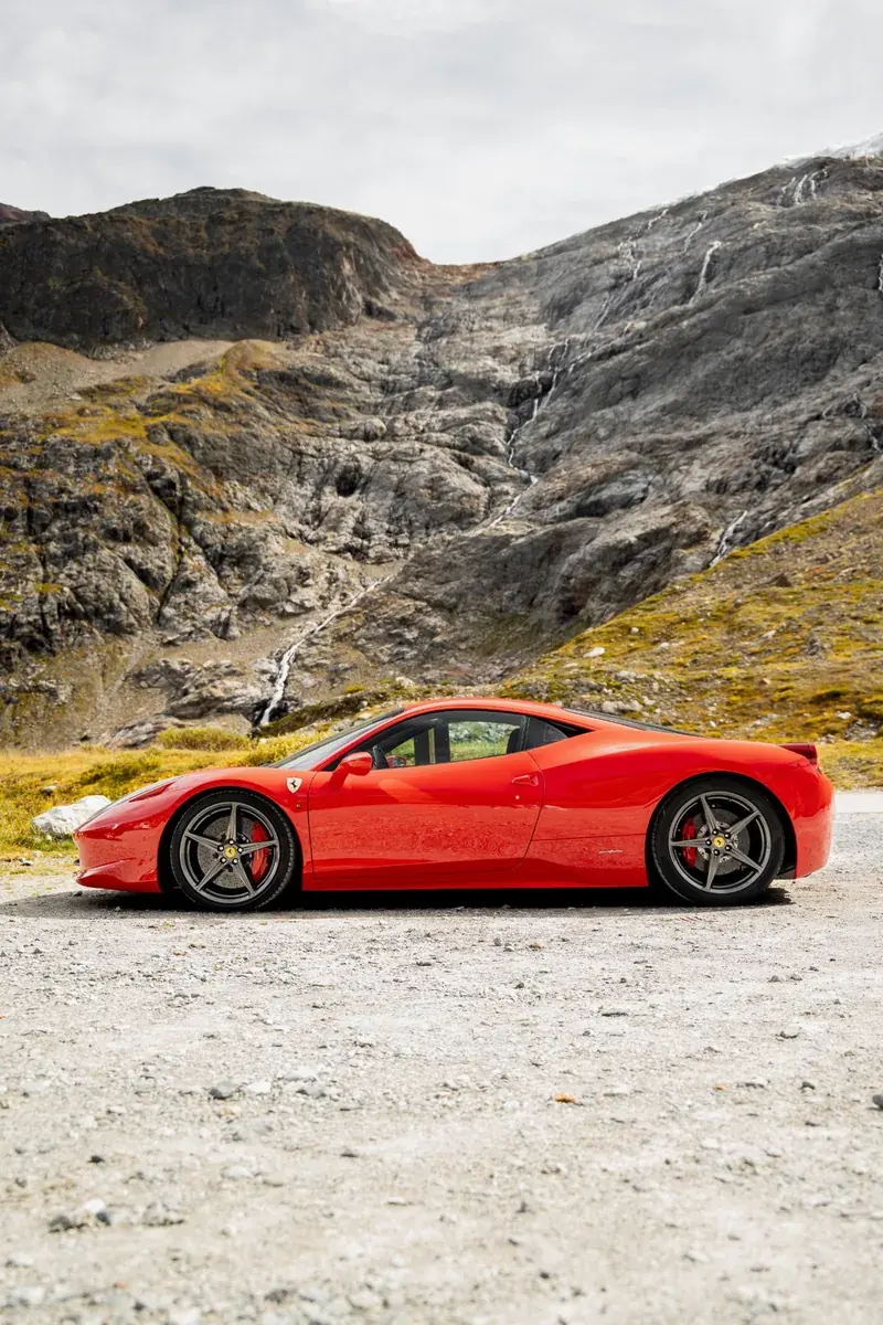 Pininfarina-Seitenlinie des roten Ferrari 458 Italia vor einem Wasserfall