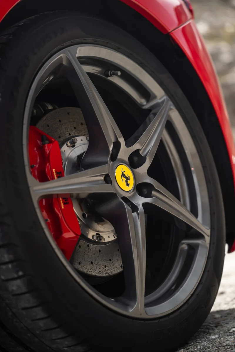 Felgendetail mit Ferrari-Emblem und rotem Bremssattel