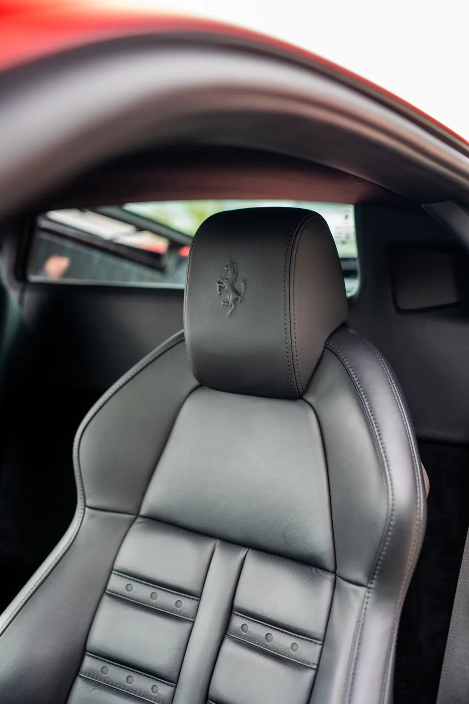 Black leather Ferrari 458 Italia seat with embossed Prancing Horse
