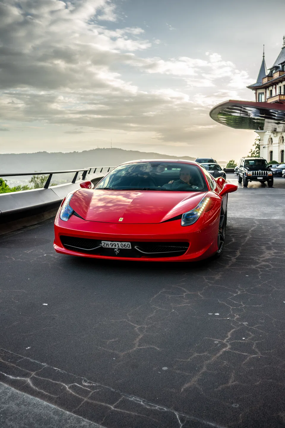 Front view of the Ferrari 458 Italia at sunset by the hotel