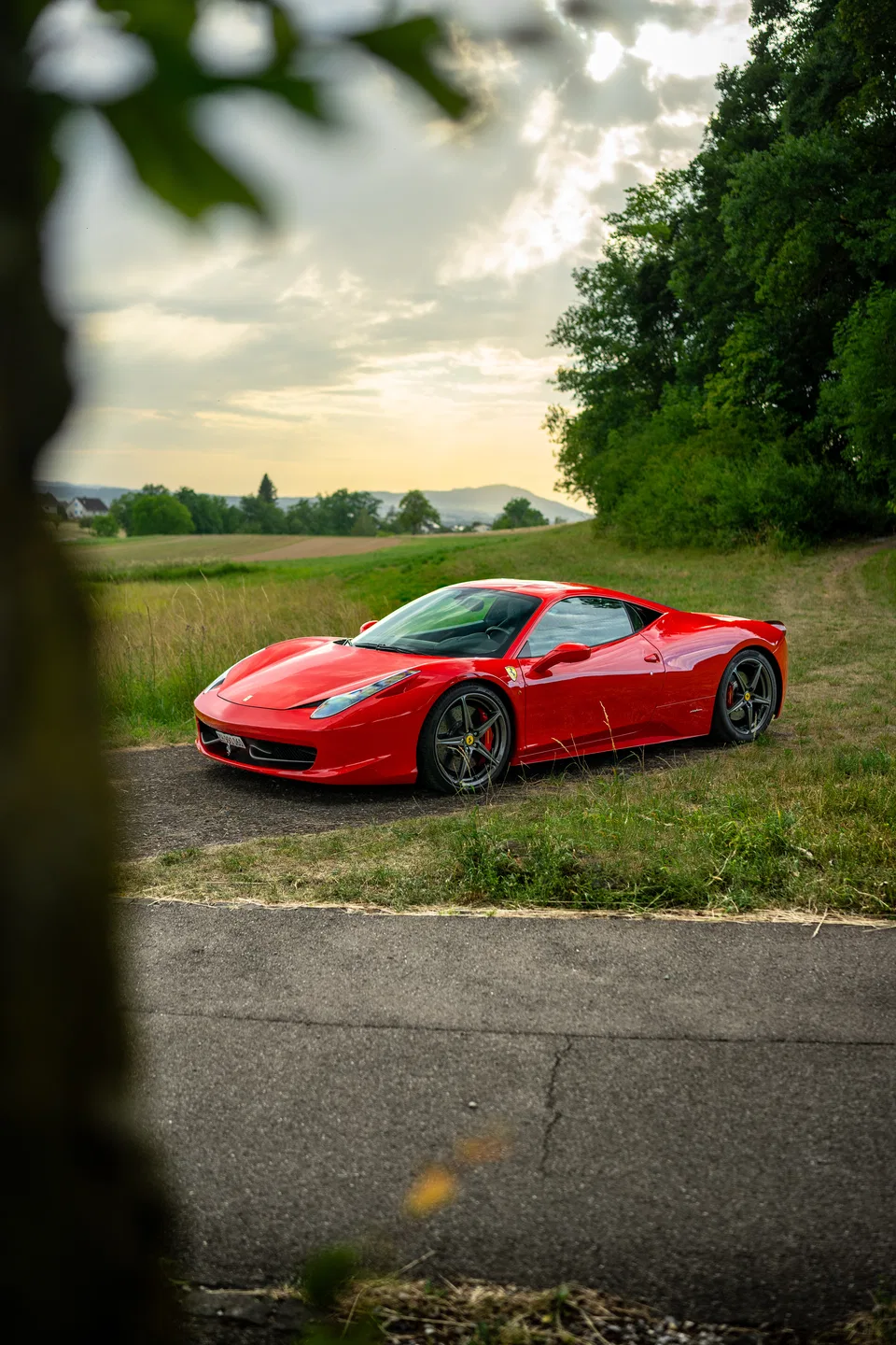 Ferrari 458 Italia framed by trees in the Swiss countryside