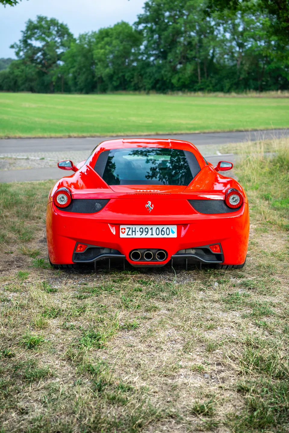 Ferrari 458 Italia viewed from the rear in an open field
