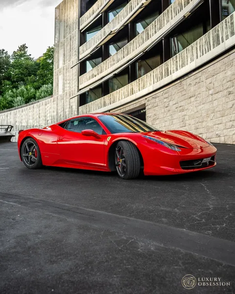 Ferrari 458 Italia neben einer modernen Hotelfassade